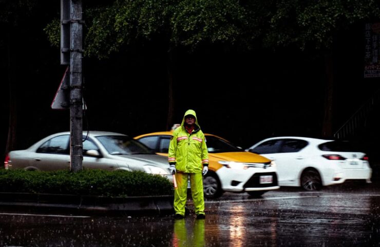 Werkman in fluogeel pak in de regen
